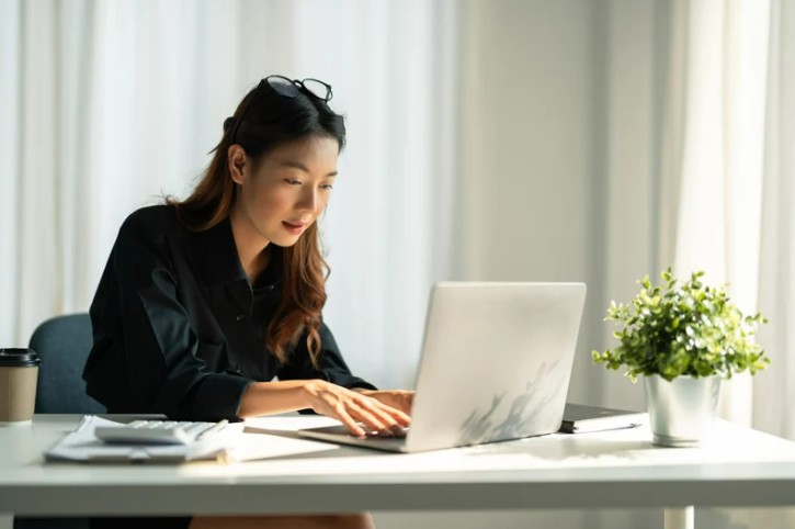 Woman sitting at desk working on laptop