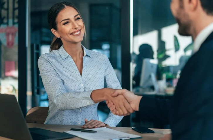 Man and woman shaking hands over a business deal