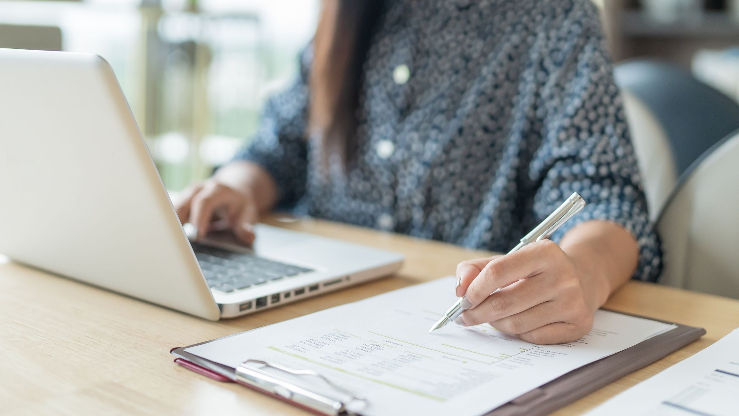 Woman working with a laptop and notepad